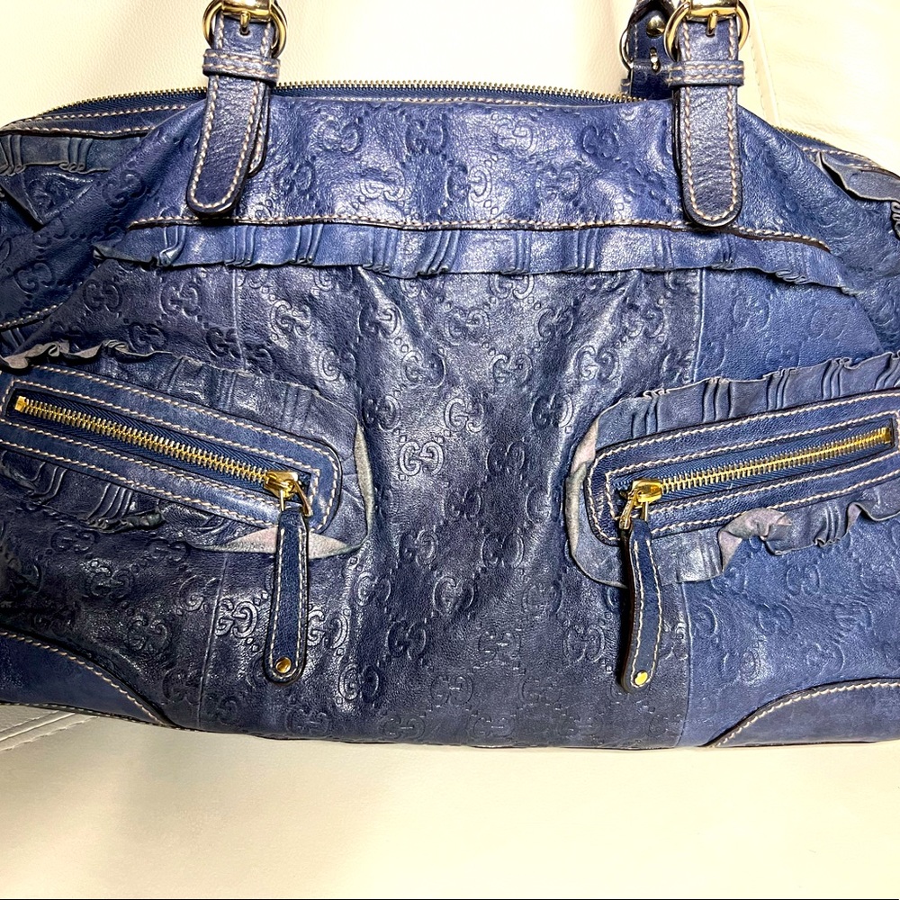 Authentic Gucci handbag with ruffle detail and gold accent.